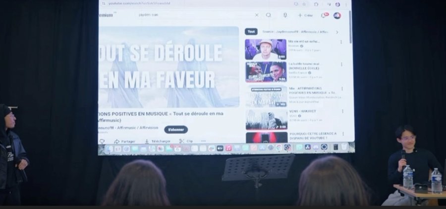 Présentation d'Affirmusic sur grand écran lors d'une conférence, avec le titre Tout se déroule en ma faveur
